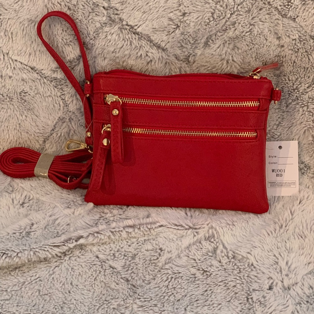 NWT red crossbody or wristlet. Long adjustable strap.
